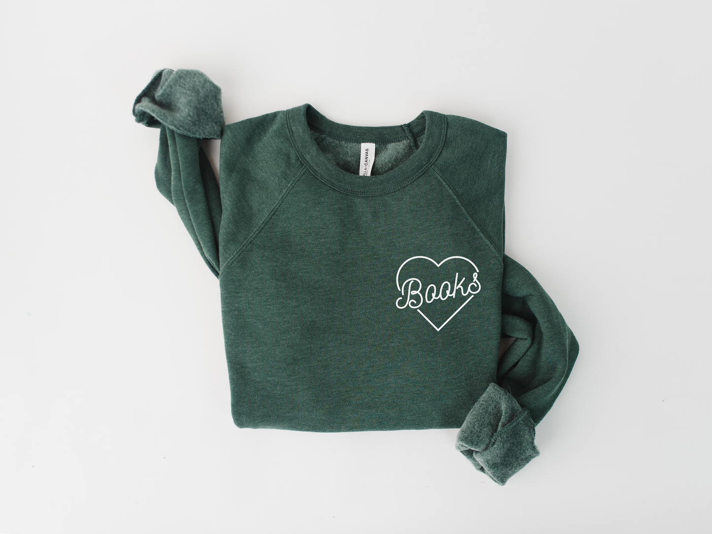 A green sweatshirt with the word "Books" printed on it, folded over one arm.