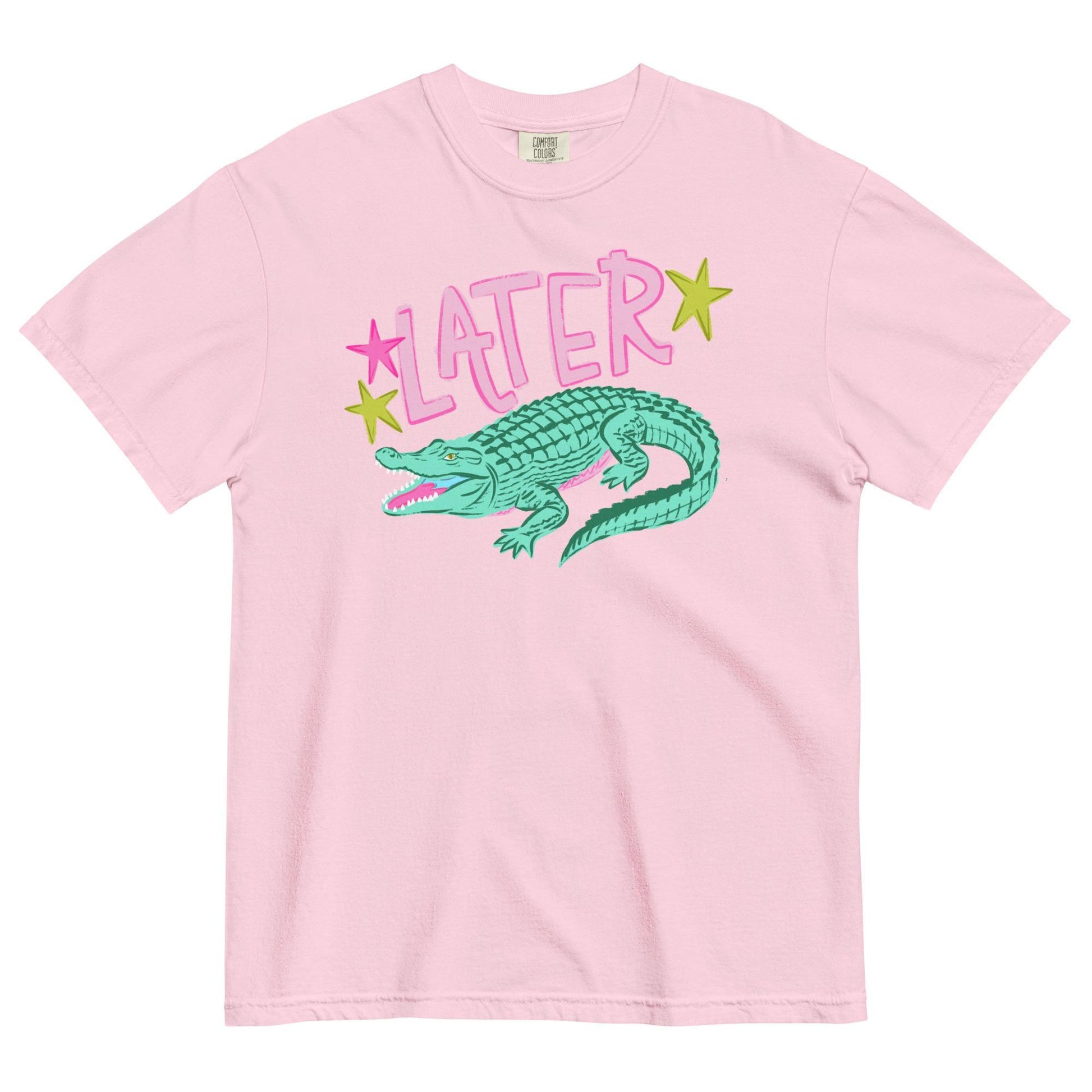 A pink t-shirt with a graphic design of a green alligator and the word "later" written above it.