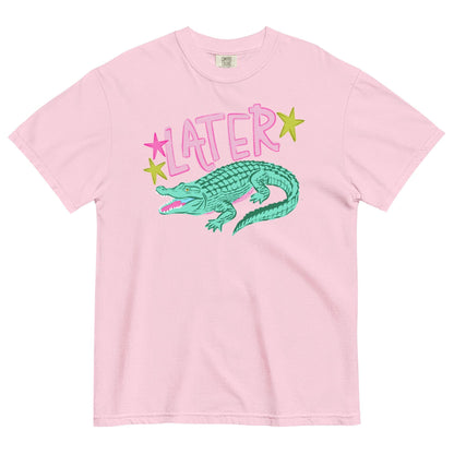 A pink t-shirt with a graphic design of a green alligator and the word "later" written above it.