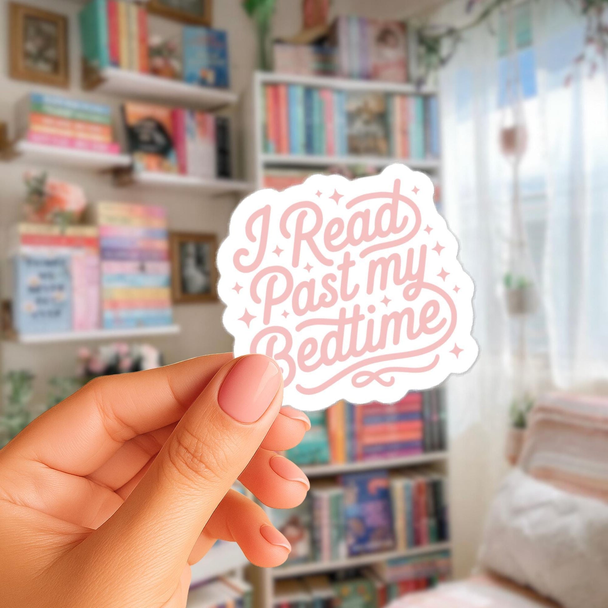 A hand holding a sticker with the text "I Read Past My Bedtime" in a room filled with bookshelves.
