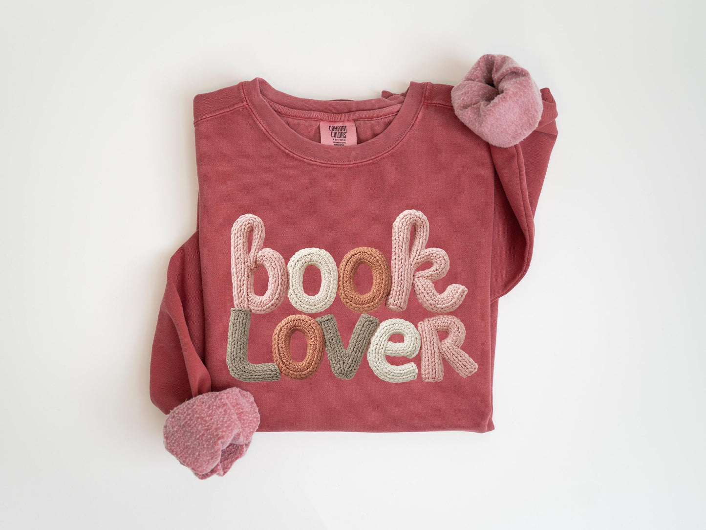 A red sweatshirt with the text "book Lover" embroidered on it.