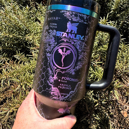 A 40 oz engraved tumbler inspired by Fourth Wing, featuring an Onyx Storm Era design with intricate dragons and fantasy book elements. This Stanley-style cup keeps drinks hot or cold for hours with double-wall insulation. Comes with a handle, sliding lid, and reusable straw—perfect for dragon book lovers and fantasy fans!