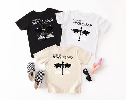 three t-shirts with the same design, two black and one white, along with a pair of checkered shoes and sunglasses.