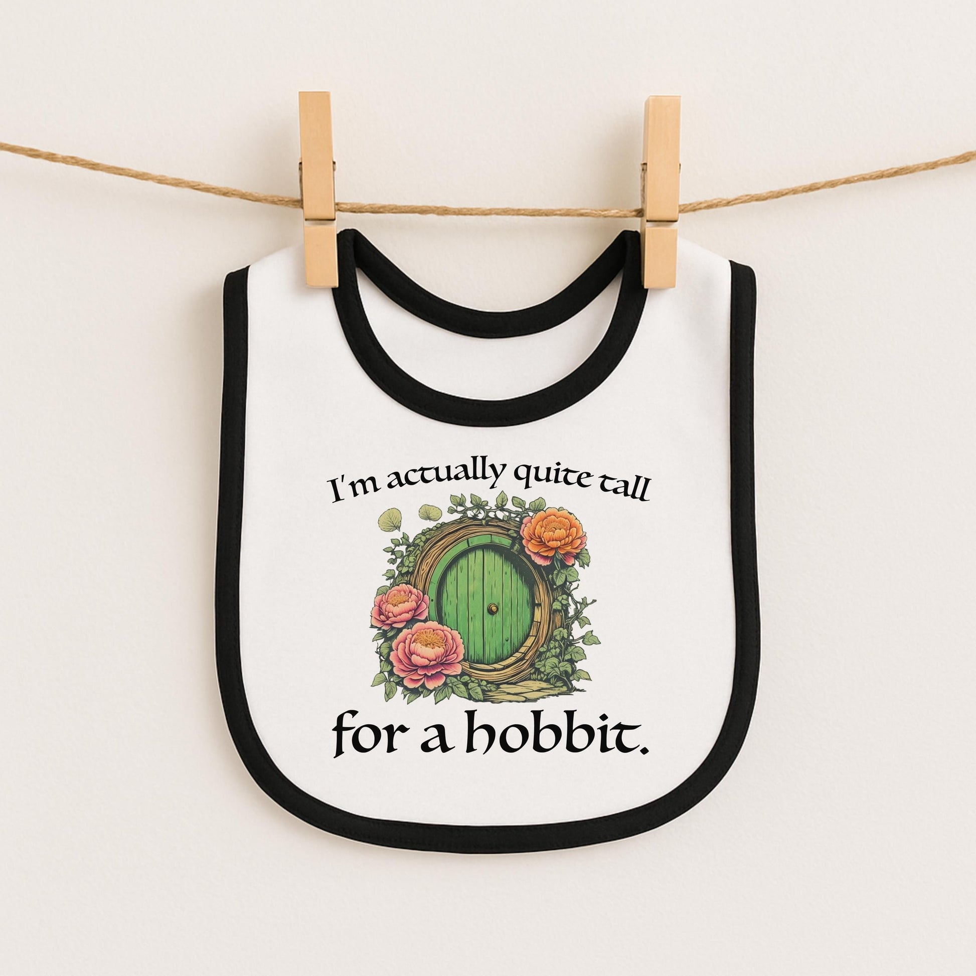A white bib with a black border and a green door with a green handle, along with a quote that says "I'm actually quite tall for a hobbit."