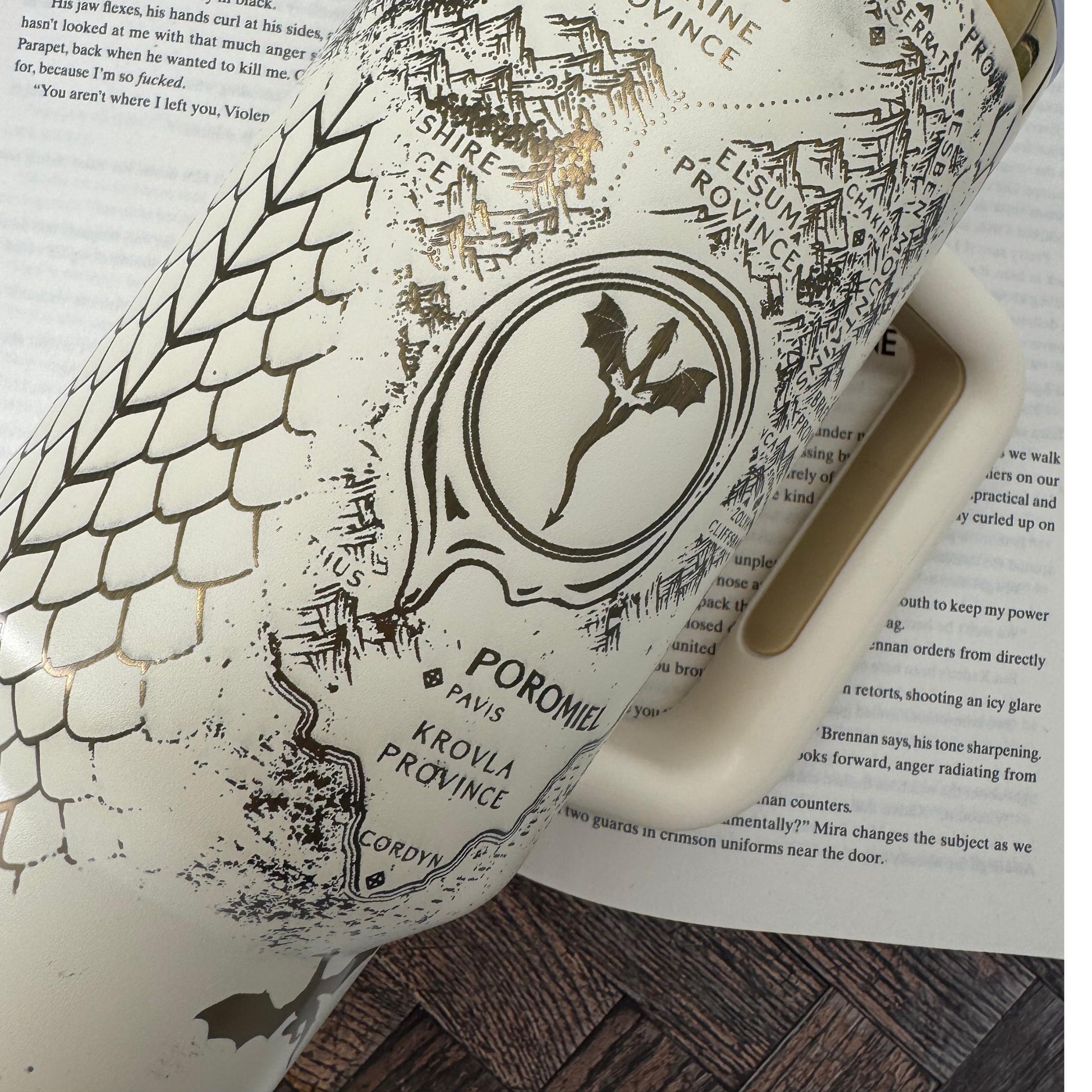 A 40 oz engraved tumbler inspired by Fourth Wing, featuring an Onyx Storm Era design with intricate dragons and fantasy book elements. This Stanley-style cup keeps drinks hot or cold for hours with double-wall insulation. Comes with a handle, sliding lid, and reusable straw—perfect for dragon book lovers and fantasy fans!