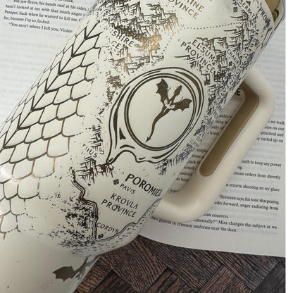A 40 oz engraved tumbler inspired by Fourth Wing, featuring an Onyx Storm Era design with intricate dragons and fantasy book elements. This Stanley-style cup keeps drinks hot or cold for hours with double-wall insulation. Comes with a handle, sliding lid, and reusable straw—perfect for dragon book lovers and fantasy fans!