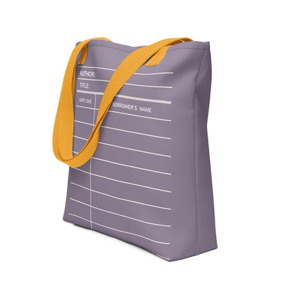 A purple tote bag with a yellow strap, featuring a white library card design on the front.